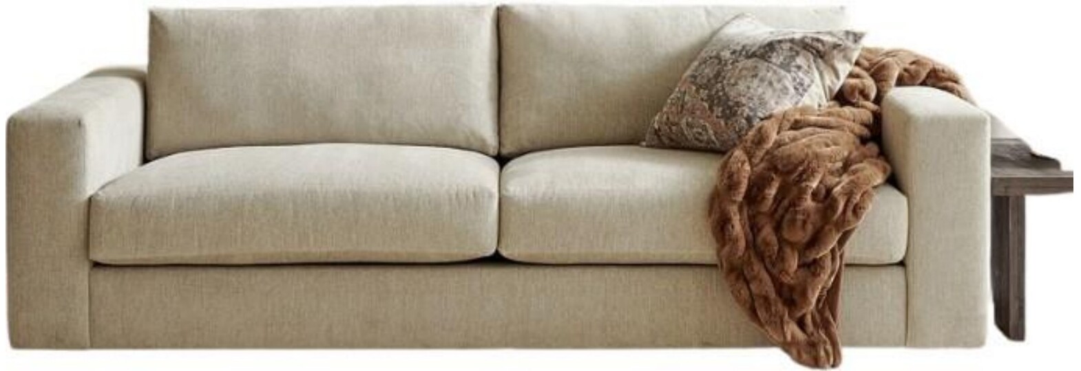 Beige two-seater sofa with patterned pillow and throw